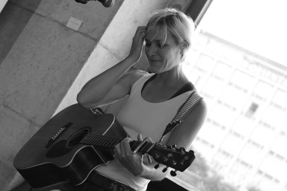 Diane A. à la guitare près d’une fenêtre