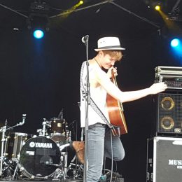 Diane A. sur une scène extérieure avec sa guitare