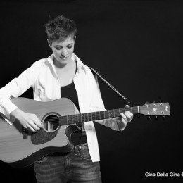 Diane A. jouant de la guitare sur scène en noir et blanc
